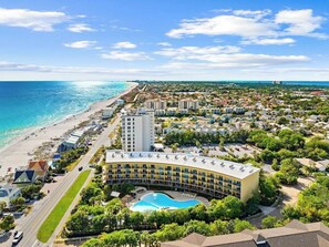 Een hotel met zwembad, direct aan het strand en meerdere gebouwen.