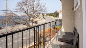 A balcony with a view of a road, trees, and a building across the street. - 1 bedroom awesome apartment in Karlobag (Karlobag)