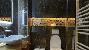 A modern bathroom with a large mirror, a sink, bidet, and a toilet. - AJ Apartments 3: City Center View Apartment (Tirana)