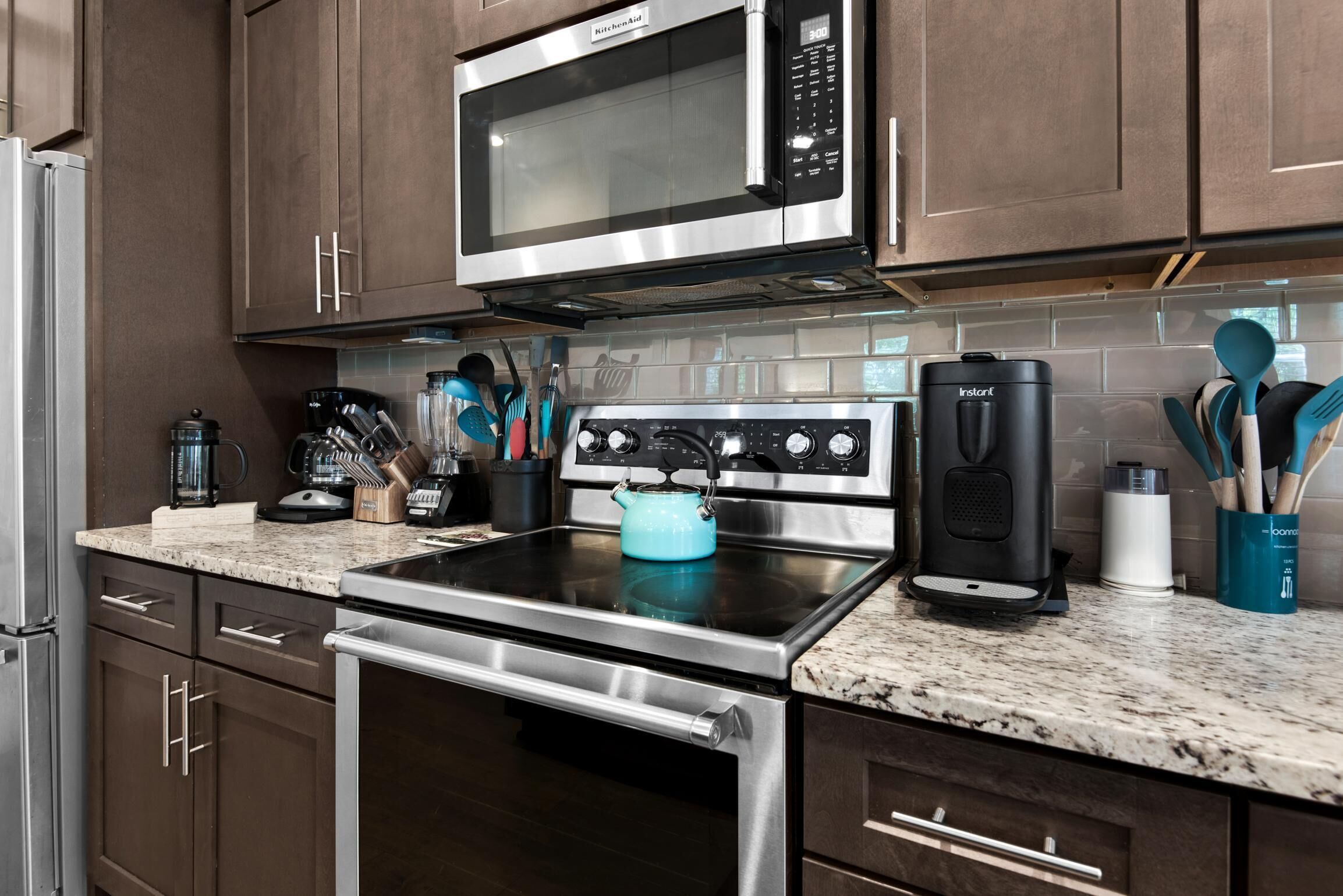 A modern kitchen with stainless steel appliances, including a microwave, oven, and coffee maker.