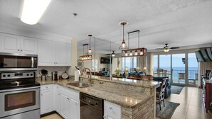 A modern kitchen with white cabinets, stainless steel appliances, and a large island. - Leeward Key 905- Suite Sea-cret (Miramar Beach)