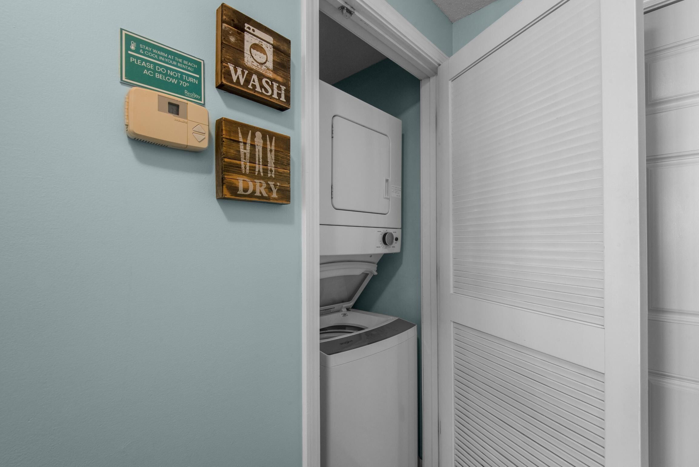 Ein Waschraum mit Waschmaschine, Trockner und einem Schild mit der Aufschrift 'WASH DRY'.