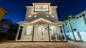 A two-story house with a balcony, a front porch, and a bicycle parked outside. - Fins Up (Destin)