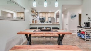 A modern kitchen with wooden cabinets, a central island, and pendant lighting. - Comal Condo - Riverfont Complex Across from Schlitterbahn (New Braunfels)