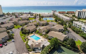 A residential area with multiple apartment buildings, a swimming pool, and a tennis court. - Chateau La Mer #5B (Destin)