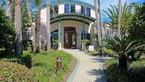 A building with a curved facade, a central entrance, and a pathway leading to it. - Bonaire Retreat (Destin)