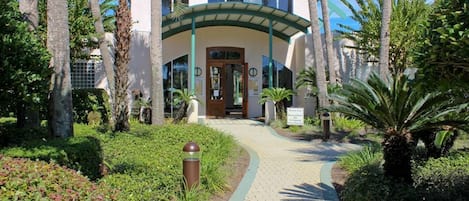 Un bâtiment doté d’une façade incurvée, d’une entrée centrale et d’un chemin menant à cette entrée.