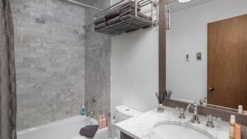 Une salle de bain équipée d’une douche, d’une baignoire, d’un lavabo et de toilettes.