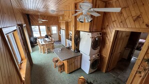 Une petite cabine comprenant un coin cuisine, un espace repas et un coin buanderie.