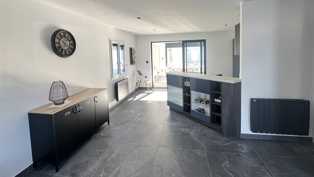 A modern kitchen with dark tiles, a wooden cabinet, and a built-in island with shelves.