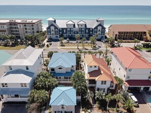 A coastal hotel with multiple buildings, including a prominent blue-roofed structure and a large building with a grey roof. - Seahaus (Destin)