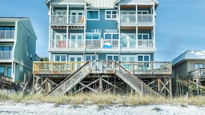 A multi-story beachfront building with balconies and a wooden deck. - Pointe of View (Destin)