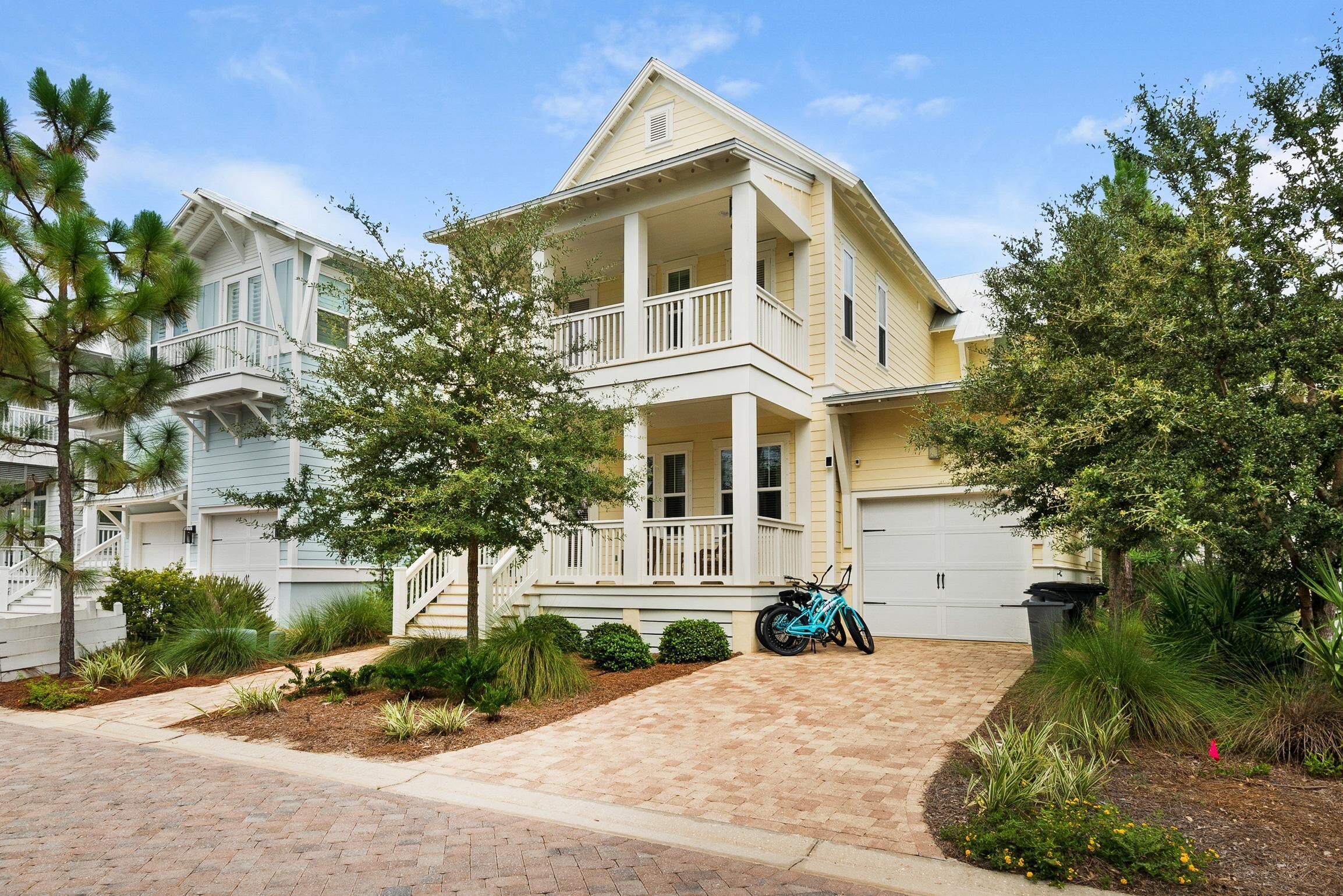 Une maison à deux étages avec un balcon, un garage et une allée.