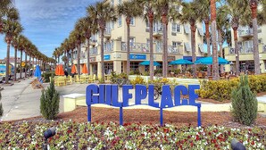 A sign reading "GULFPLACE" with a row of palm trees and a row of buildings in the background. - Topsail Village 211- Sandy Feet Retreat (Santa Rosa Beach)