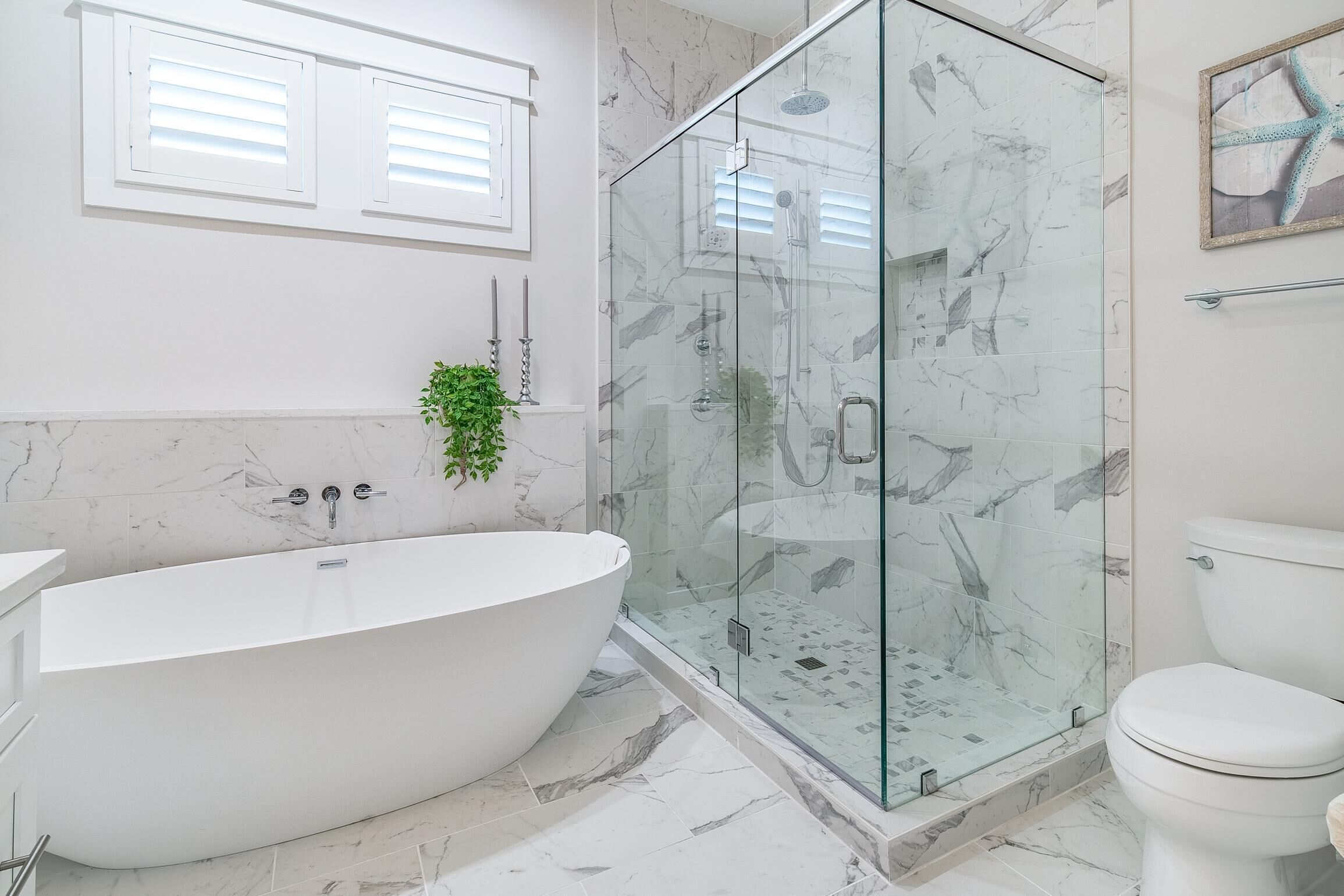 A modern bathroom with a freestanding bathtub, a glass-enclosed shower, and a toilet.