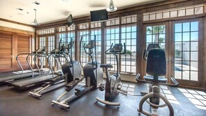 Une salle de sport équipée de tapis de course, de vélos elliptiques et de vélos d’appartement.