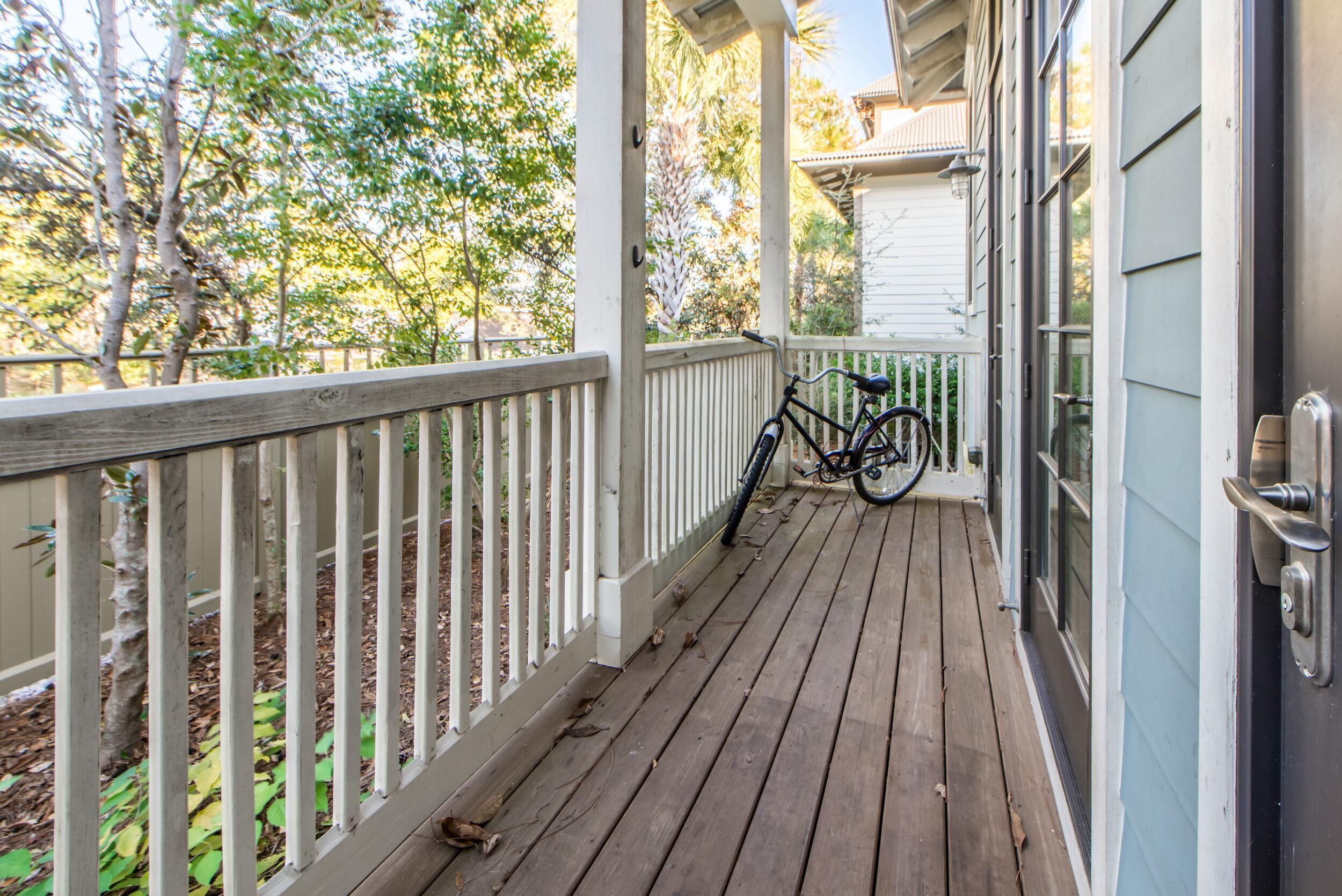 A wooden porch with a bicycle leaning against the railing.