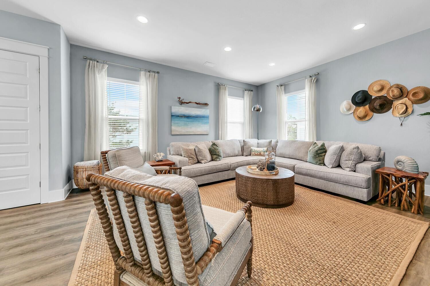 A modern living room with a sectional sofa, a round coffee table, and a wooden rocking chair.