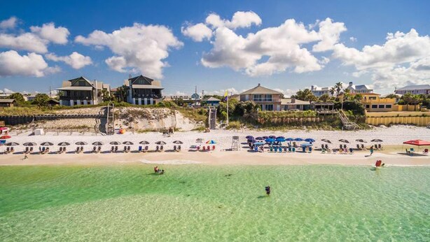A beach resort with clear turquoise waters, sun umbrellas, and beach chairs. - Sandy Cheeks (Santa Rosa Beach)