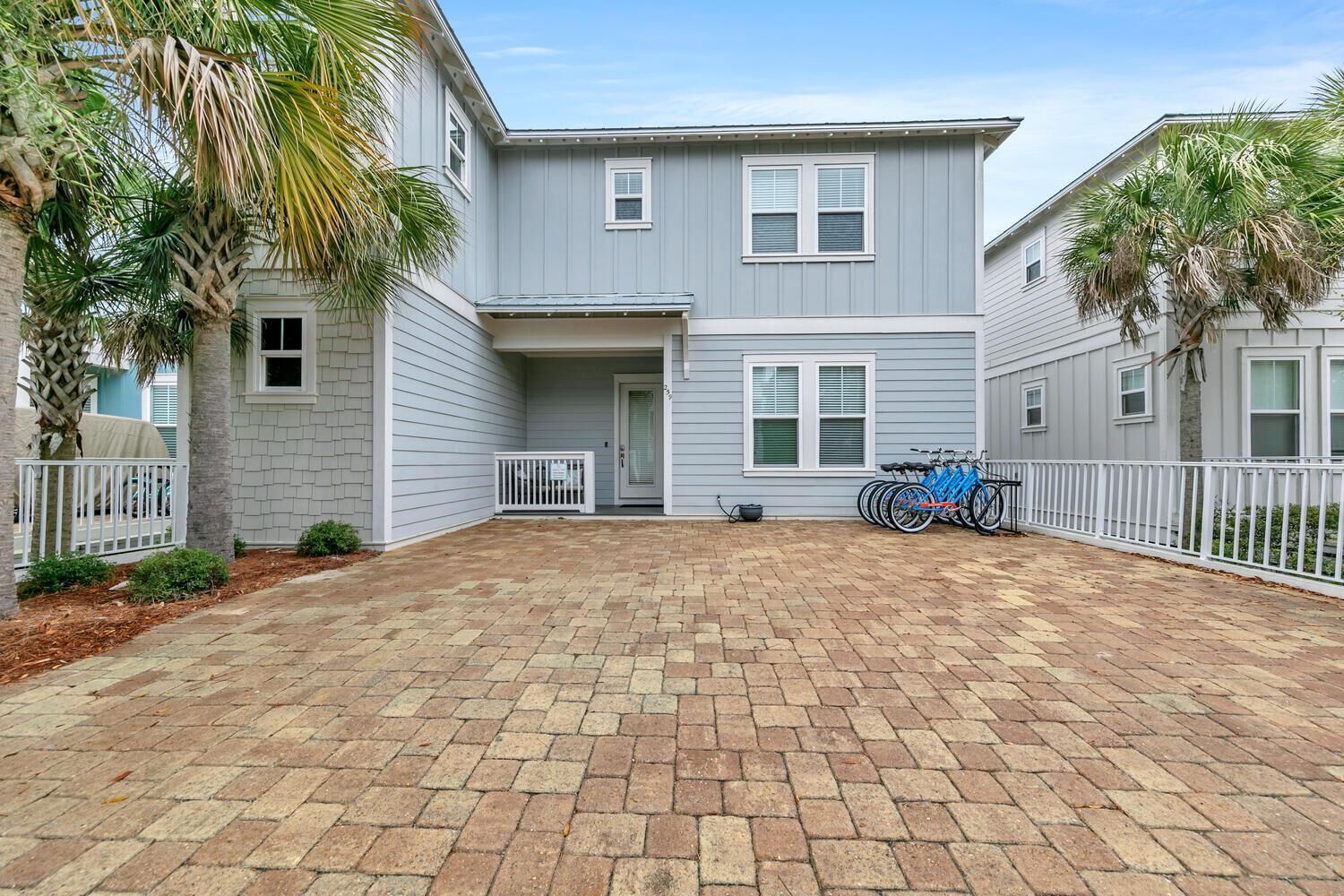 A two-story house with a covered patio area and a bicycle rack.