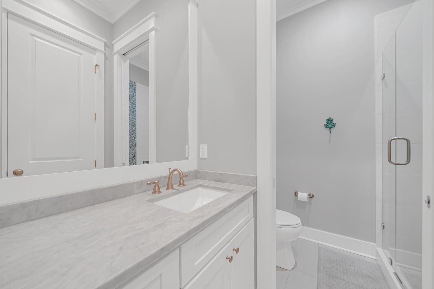 A modern bathroom with a large mirror, a white sink, and a shower area.