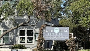Letrero de Beachy Bean Coffee Co. que muestra una lista de productos que incluye tazones de smoothie, burritos de desayuno, productos de pastelería y sándwiches de pan.