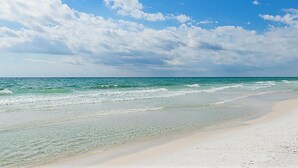 A beach with clear water and a sandy shore under a partly cloudy sky. - Gulf Place Cabanas 410- Gulf Place Getaway (Santa Rosa Beach)