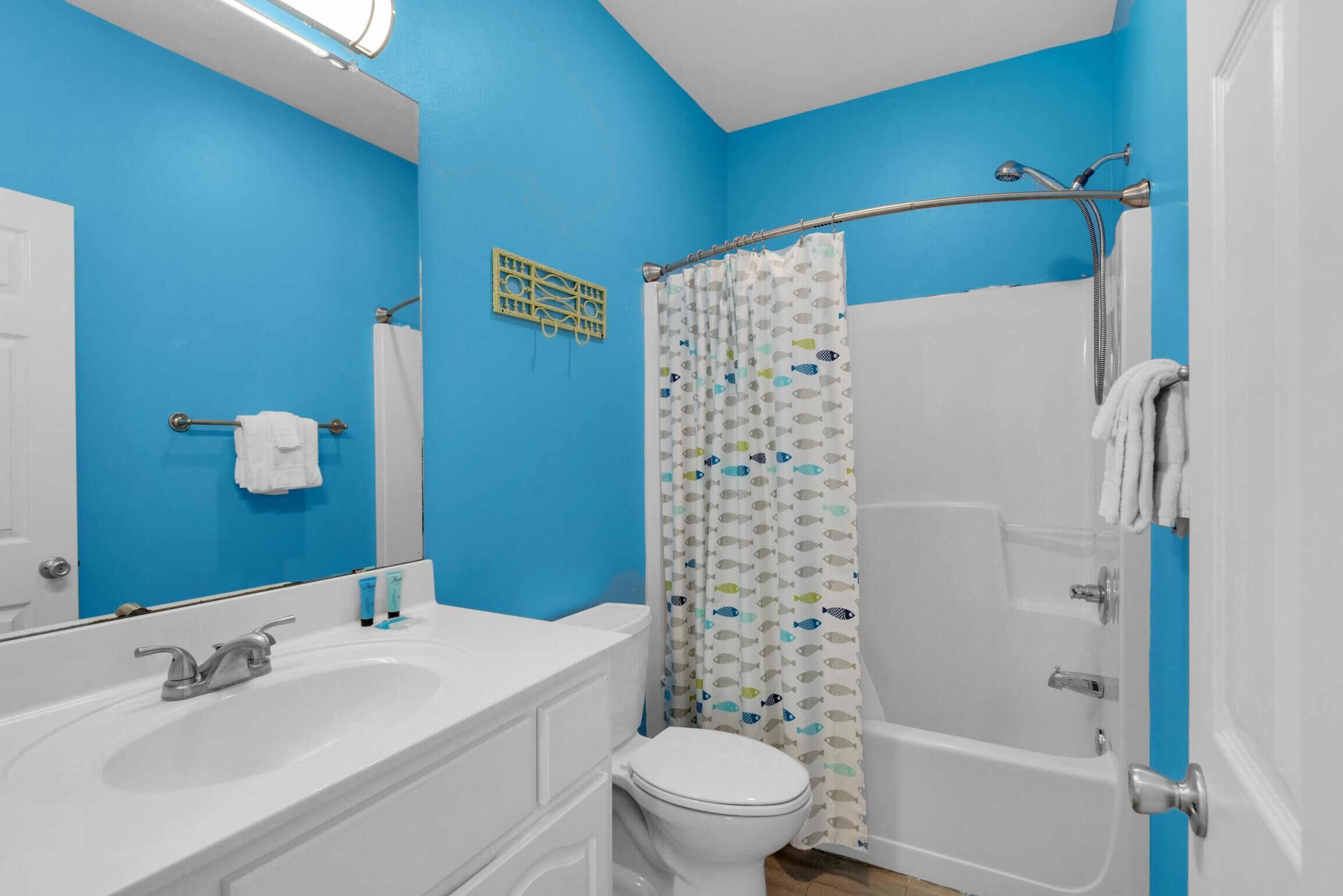 A bathroom with a white sink, toilet, and bathtub.