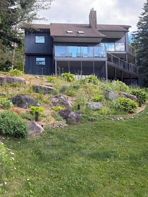 A modern two-story house with a garden in front.