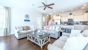 A spacious living area with a wooden coffee table, two sofas, and a ceiling fan. - Chalet Mer (Santa Rosa Beach)
