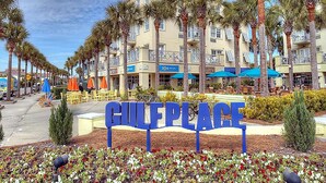 A sign reading "GULF PLACE" with a row of palm trees and buildings in the background. - Chalet Mer (Santa Rosa Beach)