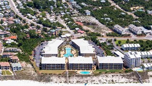 An aerial view of a resort with multiple buildings, a swimming pool, and a beach area. - Adagio F205 (Santa Rosa Beach)