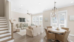 A spacious living room with a dining area, a staircase, and a ceiling fan. - Town of Prominence 326b- Seaside Paradise (Santa Rosa Beach)