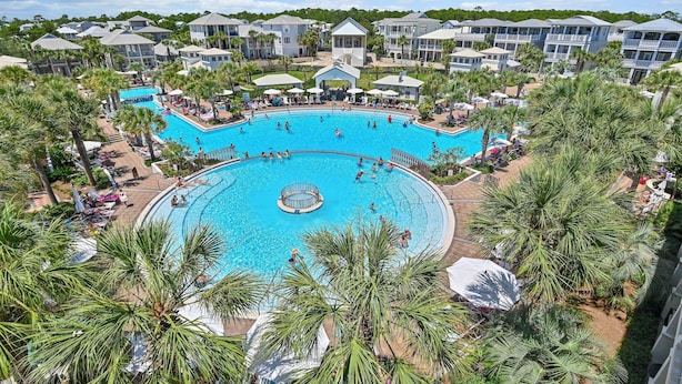Ein großer Pool im Freien, umgeben von Palmen und Hotelgebäuden.