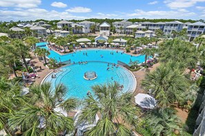Una gran piscina al aire libre rodeada de palmeras y edificios de hotel.