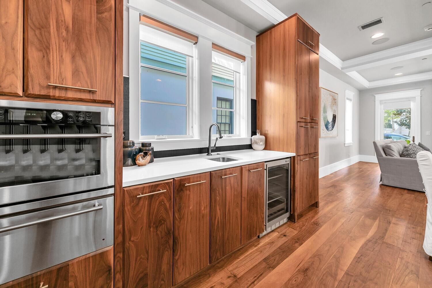 A modern kitchen with wooden cabinets, stainless steel appliances, and a large window.