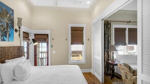 A bedroom with a large bed, a ceiling fan, and a view of a balcony. - Sunsets at Rosemary Carriage House (Panama City Beach)
