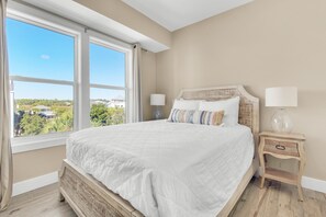 Una camera da letto con un letto grande, due comodini e vista sul verde all'esterno.