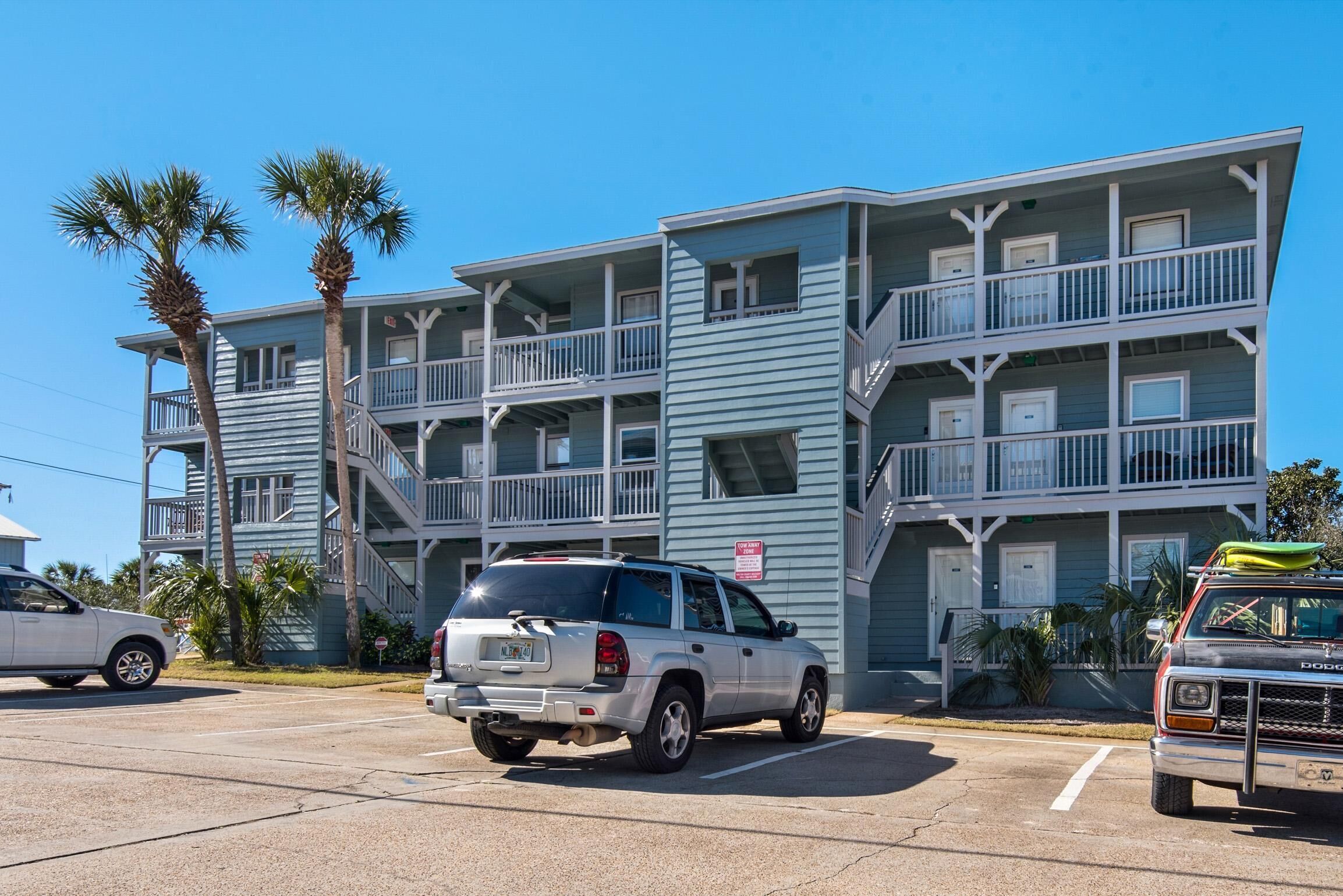 A multi-story motel with balconies and a parking lot.