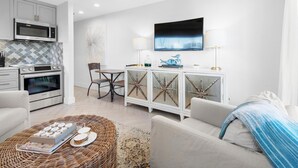 A modern kitchen with a microwave, oven, and dining area. - Inlet Sands 206- Inlet Dreams (Panama City Beach)