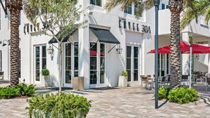 A modern building with a cafe named 'COVE 30A' and outdoor seating. - Inlet Sands 206- Inlet Dreams (Panama City Beach)