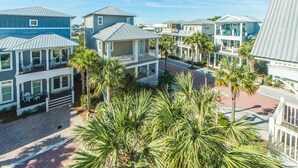 A coastal residential area with multiple houses featuring balconies and a paved walkway. - Comfort and Joy (Panama City Beach)