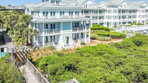A large, multi-story hotel with balconies, a covered walkway, and lush landscaping. - The Retreat 1848 (Santa Rosa Beach)