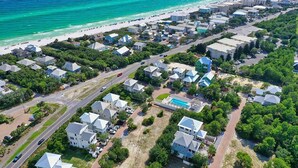 An aerial view of a coastal residential area with houses, a swimming pool, and a beach. - Stay Salty (Santa Rosa Beach)