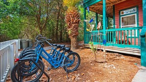 A blue bicycle parked in front of a wooden building with a green porch. - Playhouse II (Santa Rosa Beach)