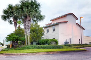 A modern building with a flat roof, large windows, and a sign indicating it is a condominium. - Palm Grove at Sago Sands Unit A (Santa Rosa Beach)