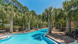 A swimming pool surrounded by palm trees and lounge chairs. - Calm Breeze Cottage (Santa Rosa Beach)