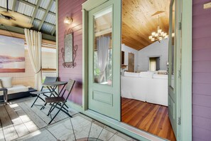 A cozy room with a wooden ceiling, a white sofa, and a small table with chairs. - Bramble Cottage (Santa Rosa Beach)