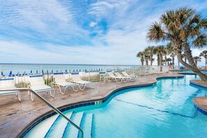 A pool area with lounge chairs and a view of the beach. - Splash 1803e (Panama City Beach)