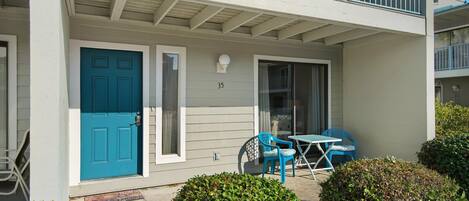 A two-story building with a blue door, number 35, and a balcony with a railing.